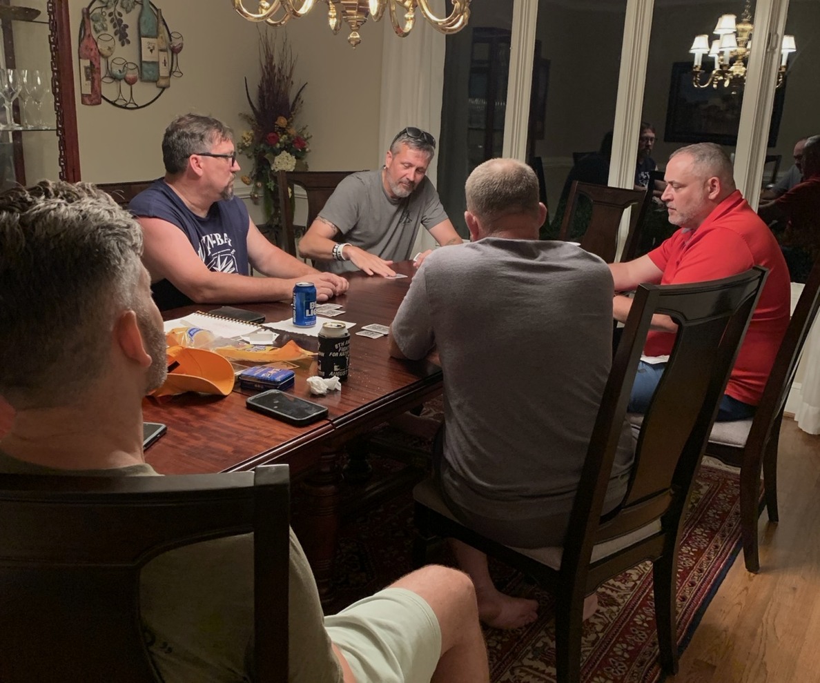 Veterans playing Spades around a dining-room table during the Charlotte trip